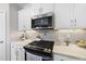 Modern kitchen with stainless steel appliances, white cabinets, and a decorative tile backsplash at 612 Sweet Pine Ln, Knightdale, NC 27545
