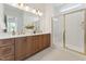 Bright bathroom featuring double vanity with wood cabinets and gold fixtures, plus a glass-enclosed shower at 640 Gainer Dr # 21, Raleigh, NC 27610