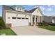 Exterior view of a two-story home featuring a white garage door, brick accents, and a driveway at 640 Gainer Dr # 21, Raleigh, NC 27610