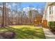 Lush green backyard with mature trees, wooden deck, and manicured landscaping at 10014 Hammock Bend Bnd, Chapel Hill, NC 27517