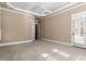 Large bedroom featuring neutral carpet, tray ceiling with fan, and access to a covered porch with white trim at 10014 Hammock Bend Bnd, Chapel Hill, NC 27517