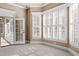 Bedroom with neutral carpet and lots of light from bay windows, with an open door to an outdoor porch at 10014 Hammock Bend Bnd, Chapel Hill, NC 27517