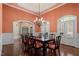 Bright dining room with chandelier, views of the backyard through multiple windows, and classic wainscoting details at 10014 Hammock Bend Bnd, Chapel Hill, NC 27517