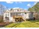 Back exterior showcasing multiple decks, screened porch, and well-manicured landscaping at 10014 Hammock Bend Bnd, Chapel Hill, NC 27517