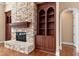Close up of the living room fireplace made of stone with built-in wooden shelving to the side at 10014 Hammock Bend Bnd, Chapel Hill, NC 27517
