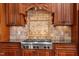 Modern kitchen with backsplash, stainless steel stove and range hood, and custom wood cabinets at 10014 Hammock Bend Bnd, Chapel Hill, NC 27517