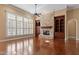 Bright living room featuring a stone fireplace, built-in shelving, large windows, and hardwood flooring at 10014 Hammock Bend Bnd, Chapel Hill, NC 27517