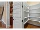 View of a pantry with white shelving and a door organizer, located next to a hallway with an arched entrance at 10014 Hammock Bend Bnd, Chapel Hill, NC 27517