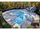 Aerial view of a refreshing swimming pool with diving board and a surrounding deck area for lounging at 102 Calm Winds Ct, Cary, NC 27513