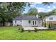 House backyard featuring a small stone patio and well-manicured lawn and shrubbery at 106 N Trail Dr, Raleigh, NC 27615