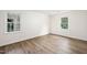 Bright and sunny bedroom with wood flooring and two windows overlooking the yard at 106 N Trail Dr, Raleigh, NC 27615