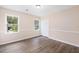 Neutral bedroom with wood flooring, three windows, and a closet at 106 N Trail Dr, Raleigh, NC 27615