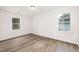 Bright and sunny bedroom featuring wood flooring and dual windows with outdoor views at 106 N Trail Dr, Raleigh, NC 27615