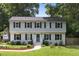 Charming two-story home with a blue door and a well-manicured front lawn at 106 N Trail Dr, Raleigh, NC 27615