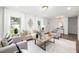 Bright living room featuring neutral furniture, large windows, and wood flooring at 106 N Trail Dr, Raleigh, NC 27615