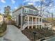 Charming two-story home featuring a covered front porch with a bright orange front door and long driveway at 107 Bond St, Durham, NC 27707