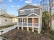 Charming two-story home featuring a covered front porch with a bright orange front door at 107 Bond St, Durham, NC 27707