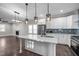 A bright kitchen with a quartz island countertop, stainless appliances and herringbone hardwood floors at 107 Bond St, Durham, NC 27707