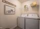 Laundry room with white washer and dryer units, shelving, and decor at 110 Cribbs Ln, Middlesex, NC 27557