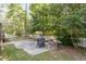 Cozy backyard featuring a brick-paved patio, a charming white picket fence, and a rustic fireplace at 1230 Auburn Village Drive Dr, Durham, NC 27713