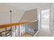 Bright hallway with carpet and wooden railings overlook the living room with hardwood floors at 1230 Auburn Village Drive Dr, Durham, NC 27713