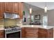 Open-concept kitchen with stainless steel gas range, granite countertops, and stylish tile backsplash at 1230 Auburn Village Drive Dr, Durham, NC 27713