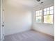 Bright bedroom features neutral colors, a carpeted floor, and ample natural light from two windows at 1243 Great Ridge Pkwy, Chapel Hill, NC 27516