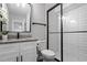 Modern bathroom featuring a granite vanity top, sleek fixtures, and a glass-enclosed shower with white subway tile at 130 S Estes Dr # G3, Chapel Hill, NC 27514