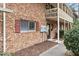 A close up view of a brick townhouse with a covered balcony and manicured landscaping at 130 S Estes Dr # G3, Chapel Hill, NC 27514