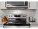 Focus on stainless steel oven and microwave, complemented by white subway tiles at 130 S Estes Dr # G3, Chapel Hill, NC 27514