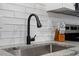 Close-up of modern kitchen sink, faucet, tiled backsplash and granite countertops at 130 S Estes Dr # G3, Chapel Hill, NC 27514