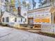 Charming white home exterior shows construction progress with Typar, a brick chimney, and white picket fence at 18 Wedgewood Ct, Chapel Hill, NC 27514