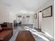 This living room features a leather sofa, a gray rug, and two windows for natural light and desk at 18 Wedgewood Ct, Chapel Hill, NC 27514