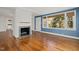 Cozy living room with hardwood floors, fireplace, and large windows at 1813 University Dr, Durham, NC 27707