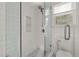 Modern shower with glass door, white subway tile, and black and white mosaic floor at 1813 University Dr, Durham, NC 27707