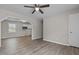 Open-concept living room featuring ceiling fan, light wood flooring, and view to adjacent kitchen at 200 Westbury Dr, Oxford, NC 27565