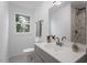 Bright bathroom features a gray vanity, white countertop, and a shower with marble-look tile at 2001 Rolesville Rd, Wake Forest, NC 27587