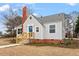 Charming bungalow with a brick chimney and a quaint blue front door at 2001 Rolesville Rd, Wake Forest, NC 27587