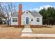 Charming bungalow-style home featuring a brick chimney and a welcoming blue front door at 2001 Rolesville Rd, Wake Forest, NC 27587