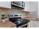 Modern kitchen with stainless steel appliances and grey backsplash at 2001 Rolesville Rd, Wake Forest, NC 27587