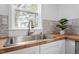 Close up on stainless kitchen sink with wood countertops and a view out the window at 2001 Rolesville Rd, Wake Forest, NC 27587