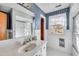 Bright bathroom featuring blue wallpaper, tiled walls, and white fixtures at 206 Eastway Ln, Graham, NC 27253
