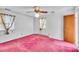 Bright bedroom features a ceiling fan, two windows, and pink carpet at 206 Eastway Ln, Graham, NC 27253