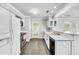 Bright kitchen with white cabinets, black appliances, tile flooring and a view to the backyard at 206 Eastway Ln, Graham, NC 27253