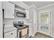 Galley kitchen with white cabinets, stainless microwave, and modern range at 206 Eastway Ln, Graham, NC 27253