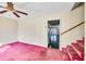 Living room featuring pink carpet, ceiling fan, and view of the staircase and back patio at 206 Eastway Ln, Graham, NC 27253