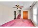 View of a living room with pink carpet, ceiling fan, staircase, closet, and wallpapered walls at 206 Eastway Ln, Graham, NC 27253