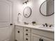 Bathroom featuring double sinks, white cabinets, granite counters, and modern fixtures at 216 Cross St, Sanford, NC 27330