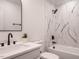 Bathroom features a tub and shower with decorative tile, modern fixtures and neutral colors at 216 Cross St, Sanford, NC 27330