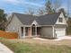 A view of the house and a wooden fence with neutral siding, a black roof, and a peach-colored front door at 216 Cross St, Sanford, NC 27330